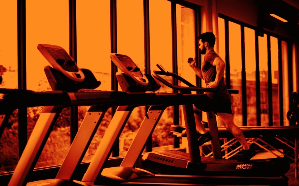 Athlete running on a curved treadmill in a bright modern gym — Pulse Fitness Collective